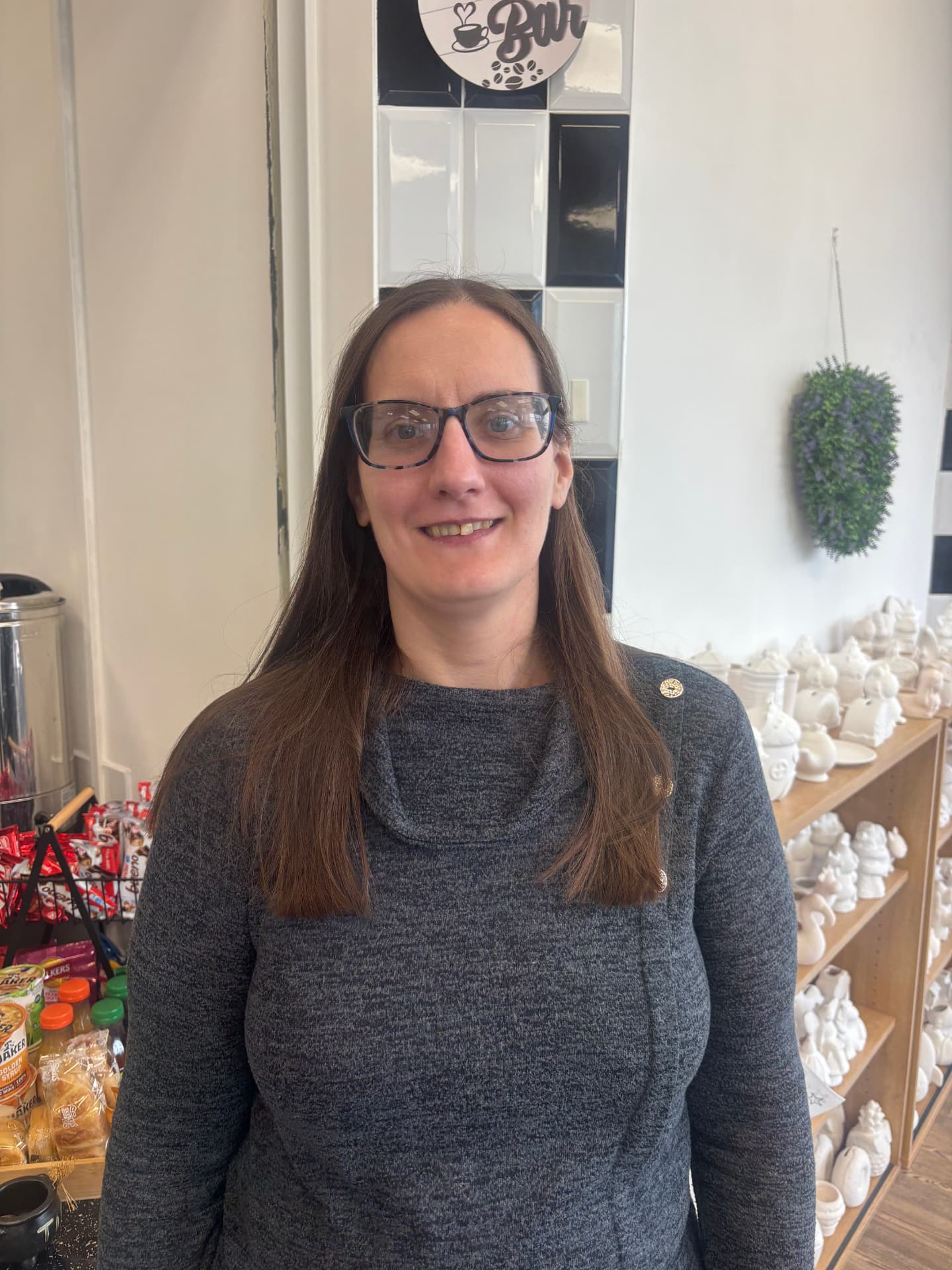 Esther smiling in her glasses by the ATT Central coffee bar