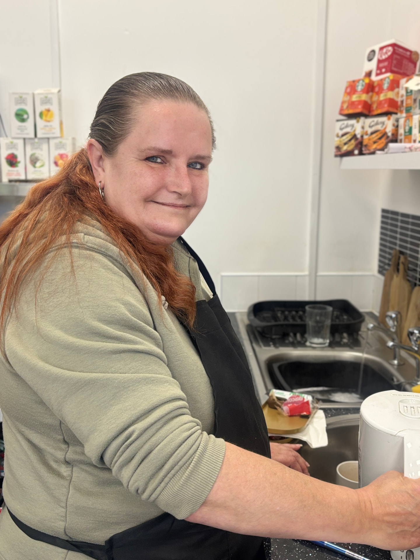 Sandra in her apron making a cuppa at the ATT Central counter
