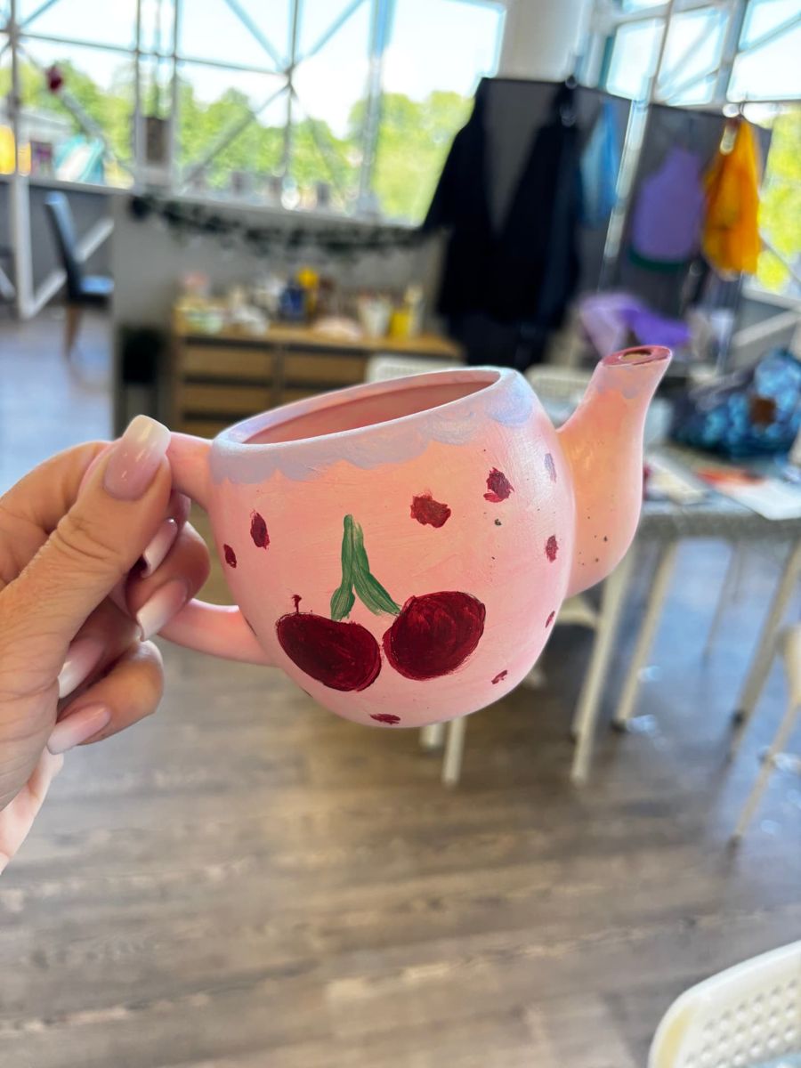 A hand-painted cherry teapot made at a pottery painting session