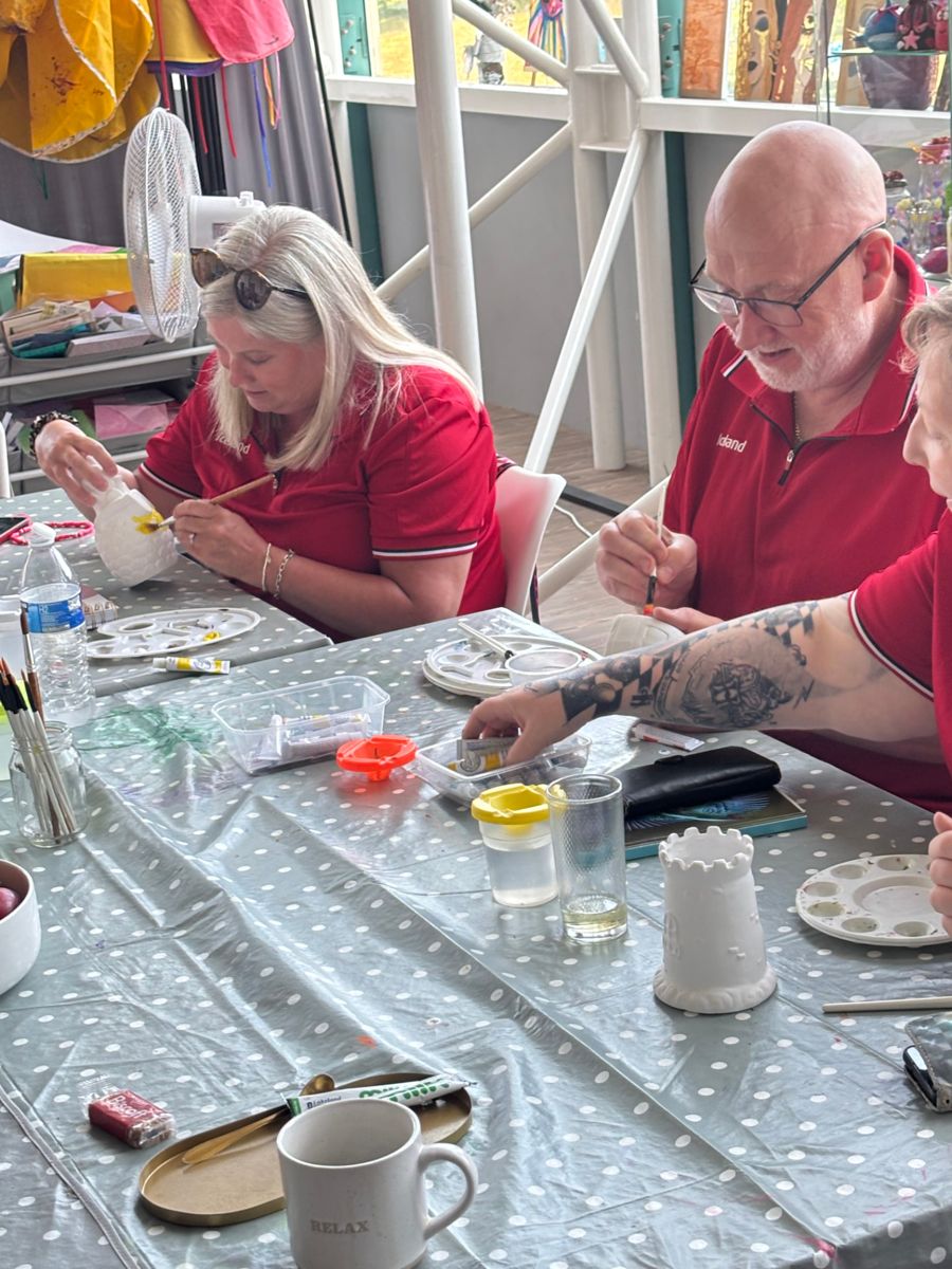 Visitors painting pottery together around a table at ATT Central